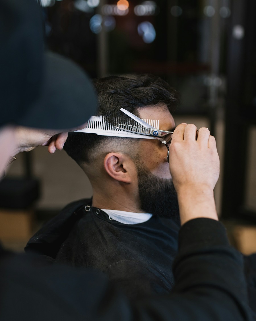 Un barbier égalise la coupe d’un client