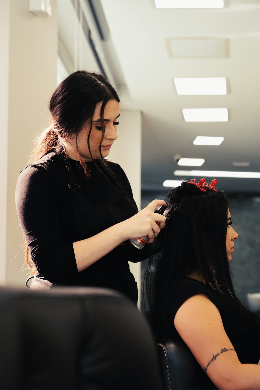 Une coiffeuse coupe les cheveux d’une cliente