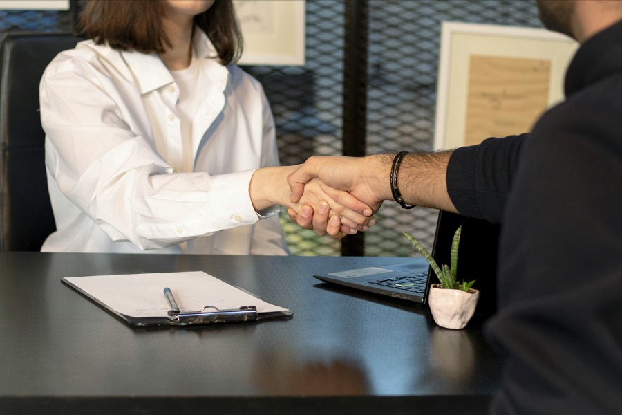 Une conseillère serre la main d’un client