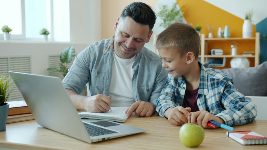 Un père et son fils font des devoirs ensemble